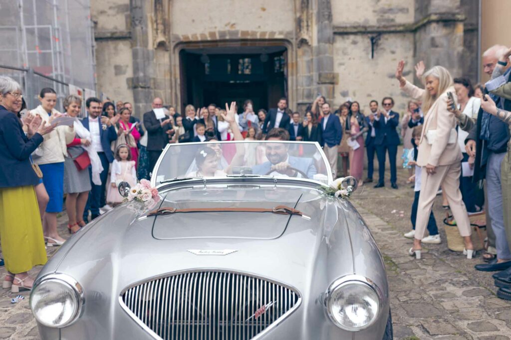 Départ des mariés en Aston Martin devant l'Eglise de St Pierre de Limours