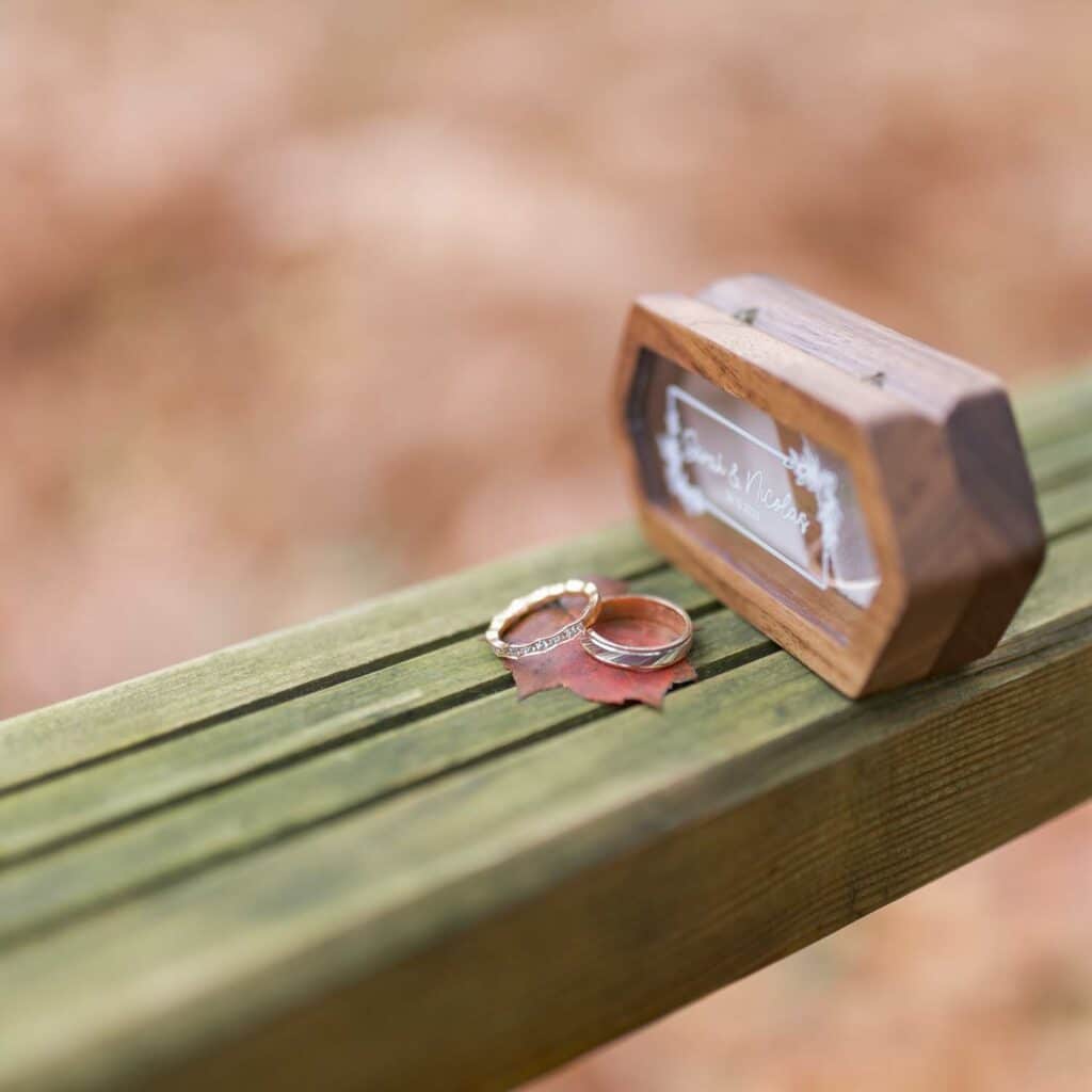 Alliances de mariage posées sur une feuille d'automne au Domaine de la Roche Couloir, symbole d'amour et de simplicité.