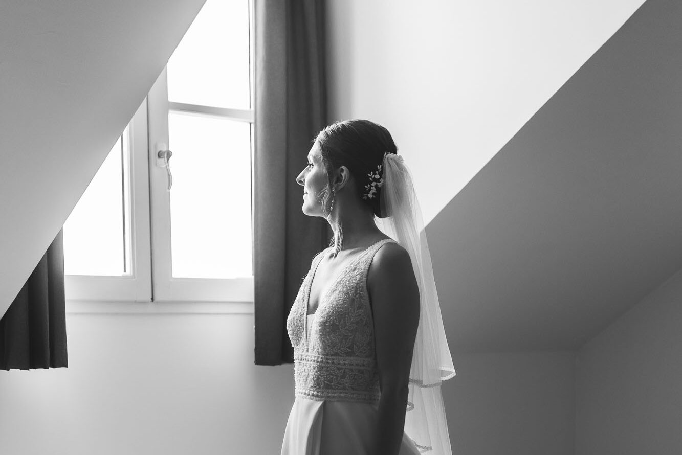 Mariée en voile près d'une fenêtre pendant les préparatifs d'un mariage à Maisons-Laffitte