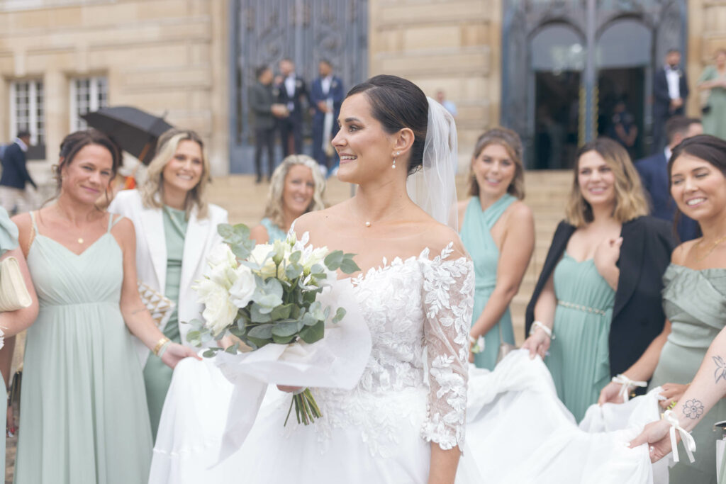 Mariée souriante entourée de ses amies devant l’hôtel de ville de Versailles