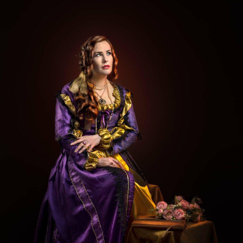 Portrait inspiré de la Renaissance, femme en costume violet et or sur fond sombre, portrait pictural en studio.