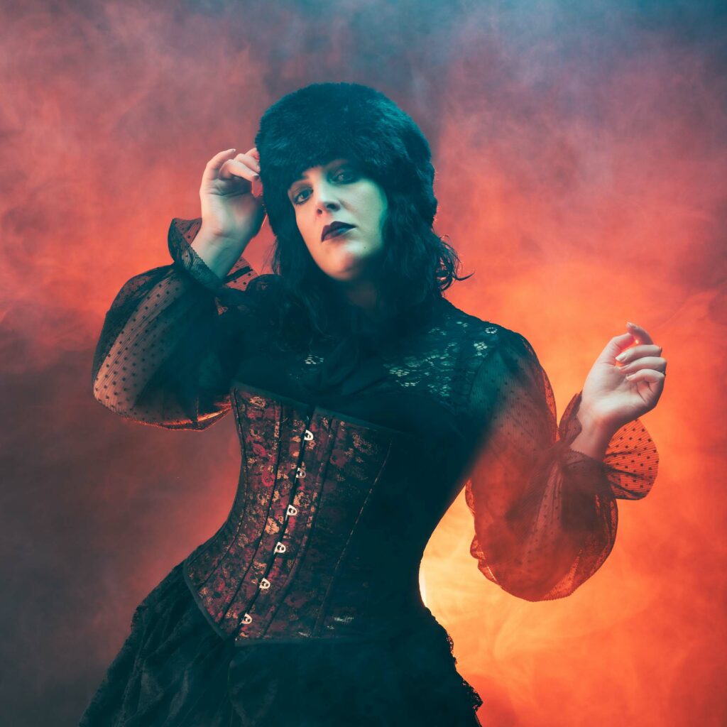 Portrait cinématographique d'une actrice dans une fumée rouge orangée et des ombres cyan, mise en scène en studio.