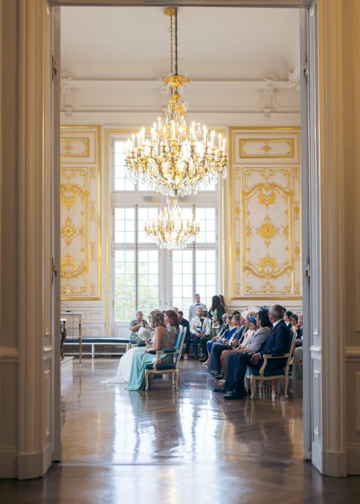 Salle des mariages de l’hôtel de ville de Versailles vue en enfilade, lustre et boiseries dorées pendant la cérémonie